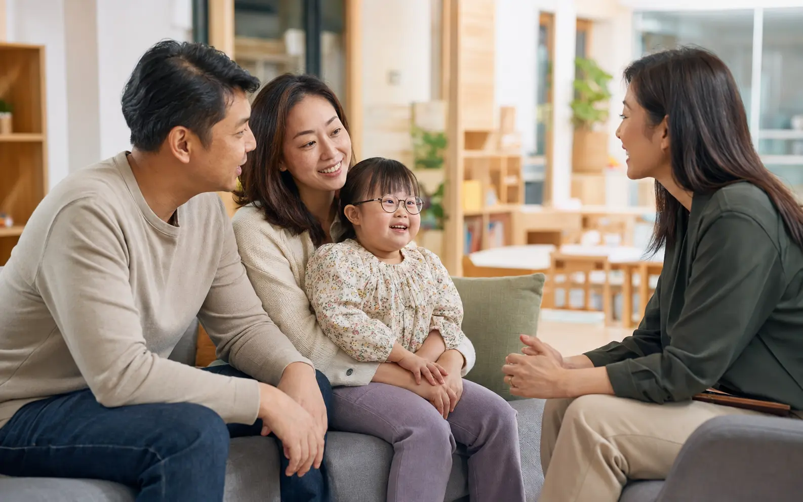 Parents and their child with Down syndrome speaking with an inclusive-education professional